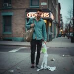 Casual Looks for Men That Always Impress Guy spilling receipts outside a flickering bodega.